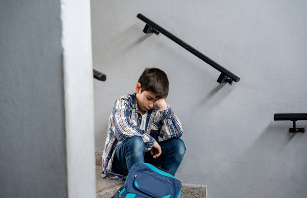 Sad child sitting on staircase