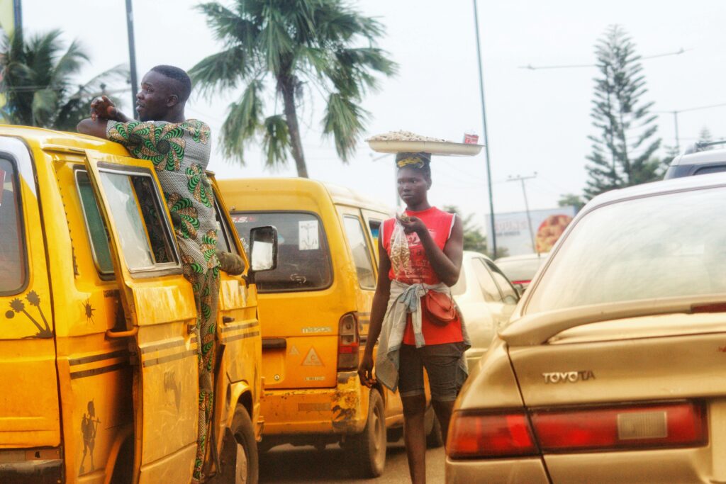 Danfo buses and conductor in heavy traffic